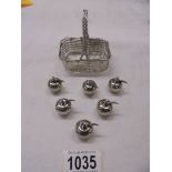 A silver plate basket and six silver plate place card holders in the shape of apples.