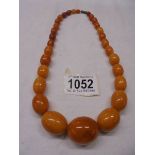 A graduated stone necklace (possibly amber), approximately 52 grams.