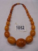 A graduated stone necklace (possibly amber), approximately 52 grams.