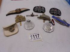 A mixed lot of badges and a yellow metal ring missing a stone.