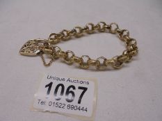 A decorative 9ct gold bracelet with ornate gold padlock and safety chain, 31.8 grams. length 20cm