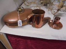 A copper foot warmer, a copper boot jug and a copper match holder.