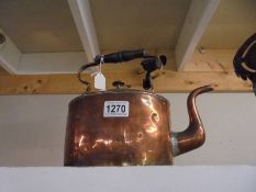 A copper kettle with brass handle.
