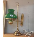 A brass student lamp with green glass shade