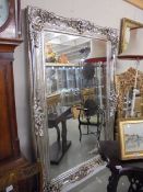 A large decorative mirror in silver coloured frame. COLLECT ONLY.