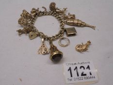 A gold charm bracelet with forteen charms, 77.7 grams.