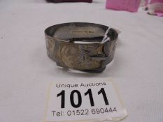 An engraved hall marked silver bangle with buckle, 50.9 grams.