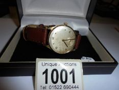 A 9ct gold gents Omega wrist watch in working order.