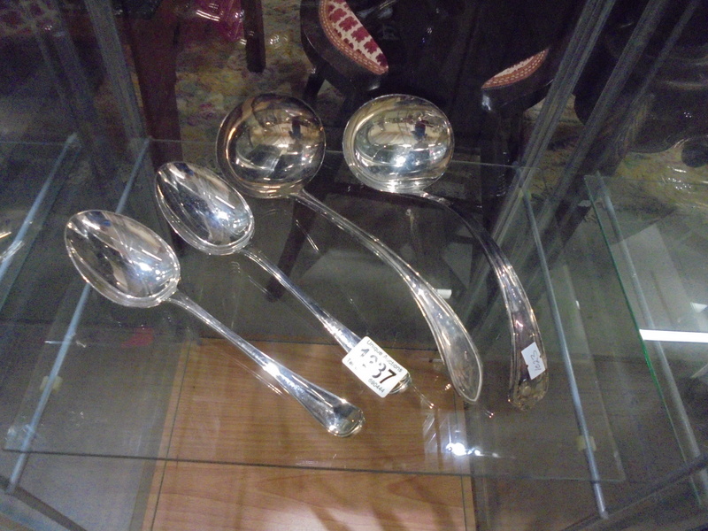 Two large soup ladles and two serving spoons.