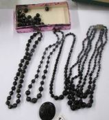 Four black bead necklaces and a 'jet' brooch.