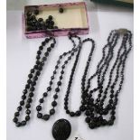 Four black bead necklaces and a 'jet' brooch.