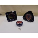 A Moorcroft trinket box and two Moorcroft ashtrays.