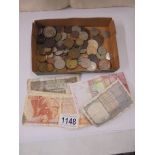 A mixed lot of foreign coins and a few bank notes.