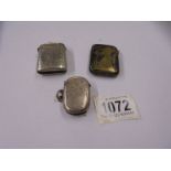 An oval silver vesta case and two others in white metal,