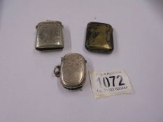 An oval silver vesta case and two others in white metal,