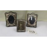 A pair of small silver photo frames and a smaller example.