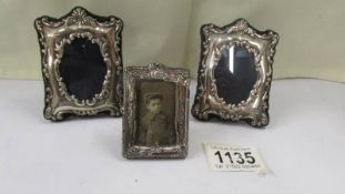 A pair of small silver photo frames and a smaller example.