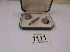 A pair of hand engraved vintage silver cuff links together with a tie clip.