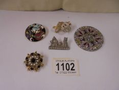 An antique brooch set red stone and seed pearls and four other brooches.