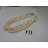 A three row natural pearl necklace.