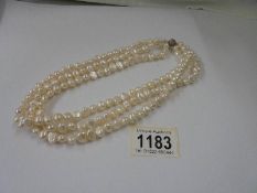 A three row natural pearl necklace.