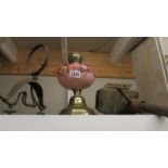 A Victorian oil lamp with pink glass font, a coach/porch lamp and a wall bracket.