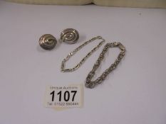 Two silver bracelets and a pair of silver earrings, 27.6 grams.