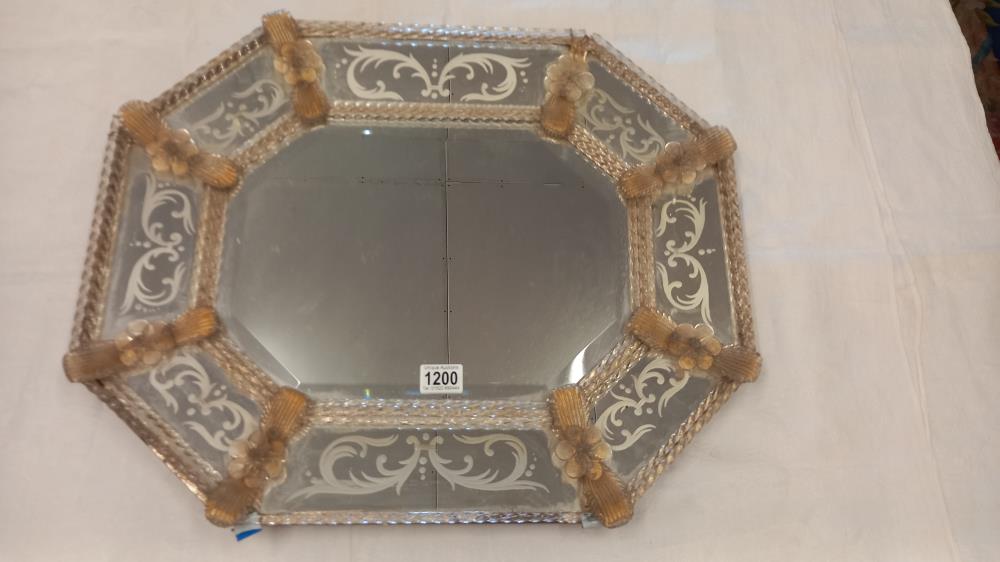 A 1920s venetian wall mirror, the elongated octagonal cushion shaped frame with gilt flower dividers