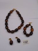 An amber coloured necklace, bracelet and earrings.