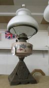 An old oil lamp on cast base with hand painted glass font and opaque glass shade, COLLECT ONLY.