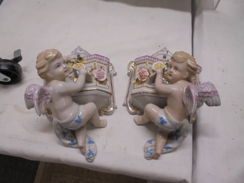 A pair of porcelain cherub wall pockets.