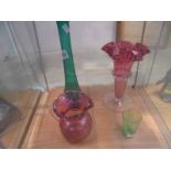 A Victorian cranberry glass vase and jug, a green Mary Gregory glass and a tall glass spill vase.