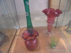 A Victorian cranberry glass vase and jug, a green Mary Gregory glass and a tall glass spill vase.