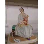 A signed Capo-Di-Monte figure of a mother with child.