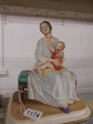 A signed Capo-Di-Monte figure of a mother with child.