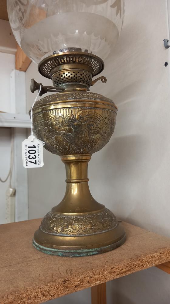 A Victorian oil lamp with embossed brass base and original etched shade. COLLECT ONLY. - Image 2 of 3
