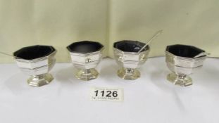 A set of four silver salts with blue glass liners with three spoons, silver weight 6.5 ounces.