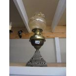 An oil lamp on metal base with brass font and later shade, COLLECT ONLY.