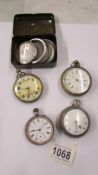 Four old pocket watches and some watch parts.