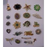 Twenty assorted costume brooches.