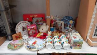 A good selection of Rupert The Bear collectables including pottery, books & glove puppet etc.