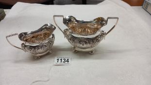 A decorative silver sugar bowl and cream jug, 7 ounces.