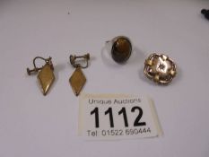 A pair of yellow metal earrings, a yellow metal brooch and a white metal ring.