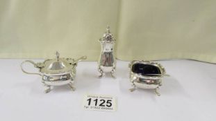 A three piece silver condiment set with blue glass liners, 4 ounces.