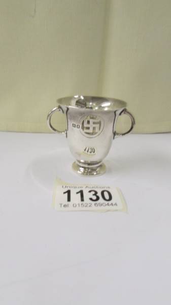 A small silver two handled pot with swastika emblem. 38.5 grams/