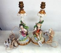A pair of porcelain table lamps featuring boy and girl figures.