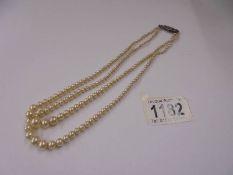 A double row pearl necklace with silver clasp.