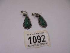 A pair of vintage silver pendant earrings featuring Mexican faces (possibly jade).