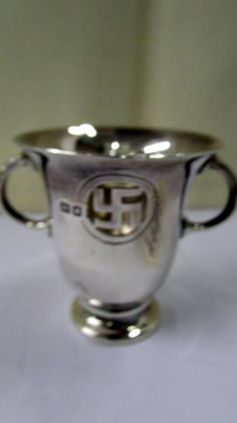 A small silver two handled pot with swastika emblem. 38.5 grams/ - Image 2 of 2