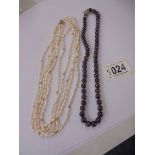 A five strand pearl necklace with a 14k gold clasp and one other necklace.